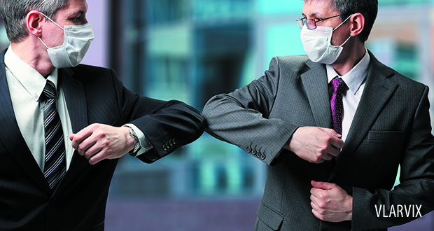 Businessmen in masks bumping elbows