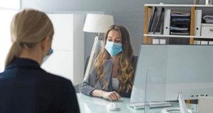 Workers wearing masks in office meeting