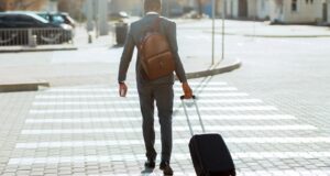 Worker crossing street with luggage for travel